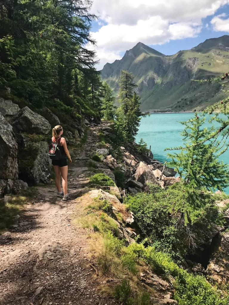 Escursionista sul sentiero didattico lungo la riva del Lago Ritom nella Val Piora