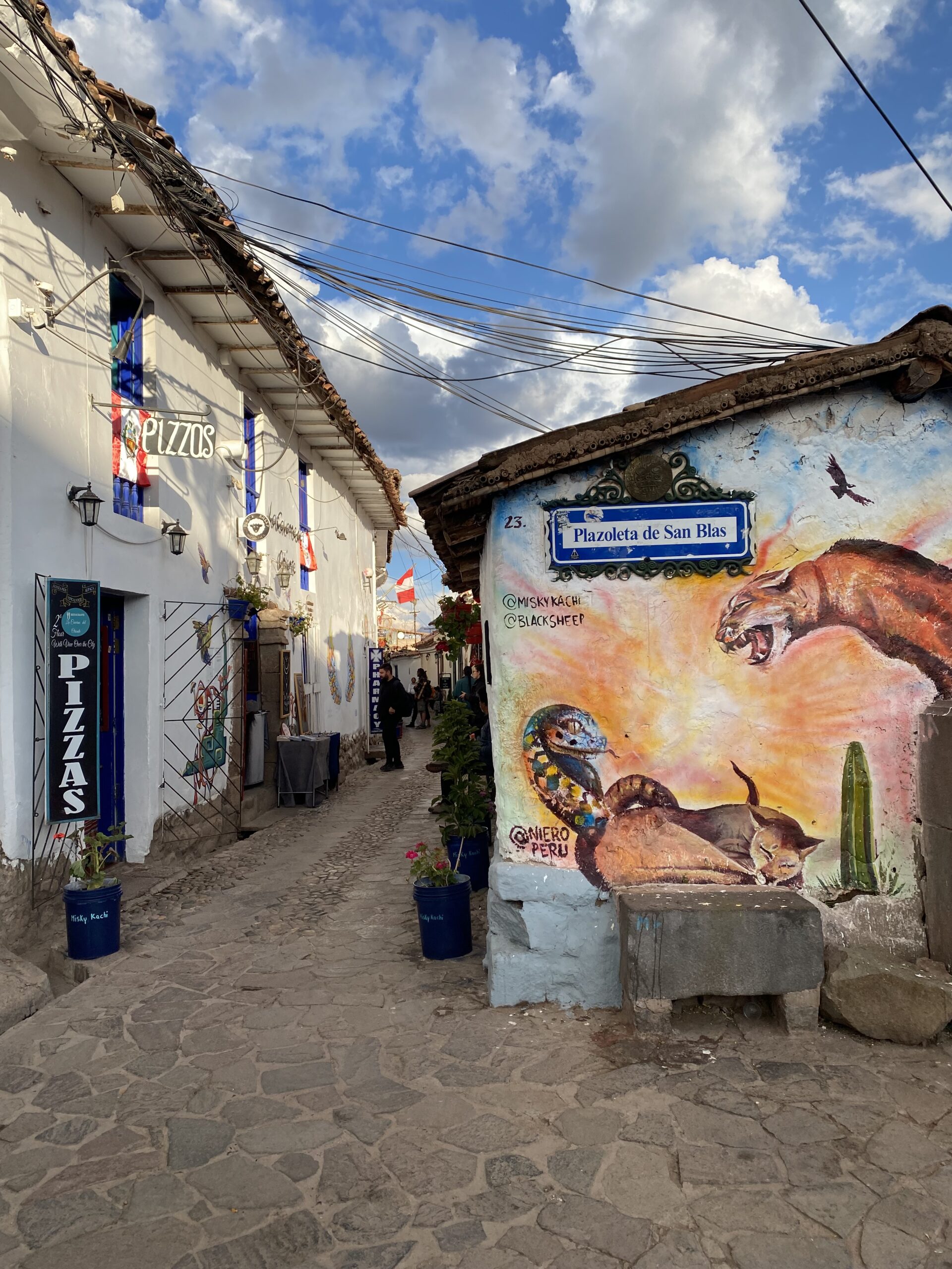 Stradina acciottolata con murales nella Plazoleta de San Blas a Cusco, Perù