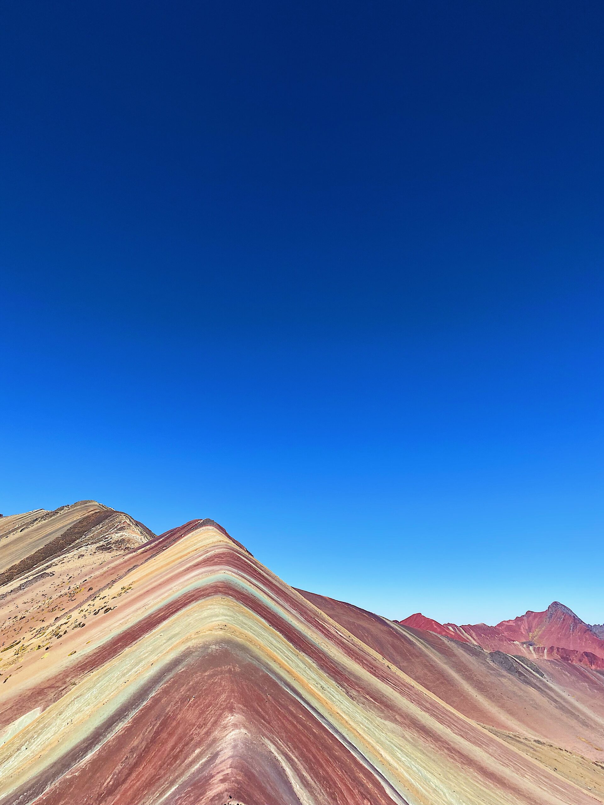 Panorama della Rainbow Mountain in Perù sotto cielo blu intenso