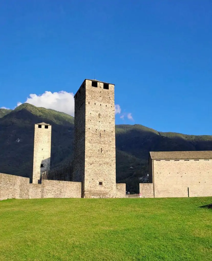 La Torre Bianca e le mura di Castelgrande a Bellinzona, patrimonio UNESCO, sotto un cielo azzurro