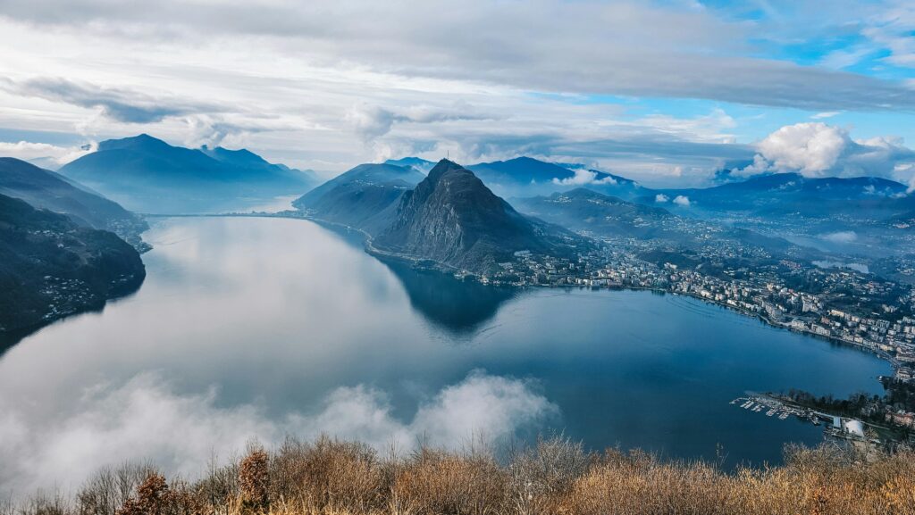Vista panoramica del Monte San Salvatore e del golfo di Lugano avvolti dalle nuvole, ripresi dal Monte Brè in Ticino