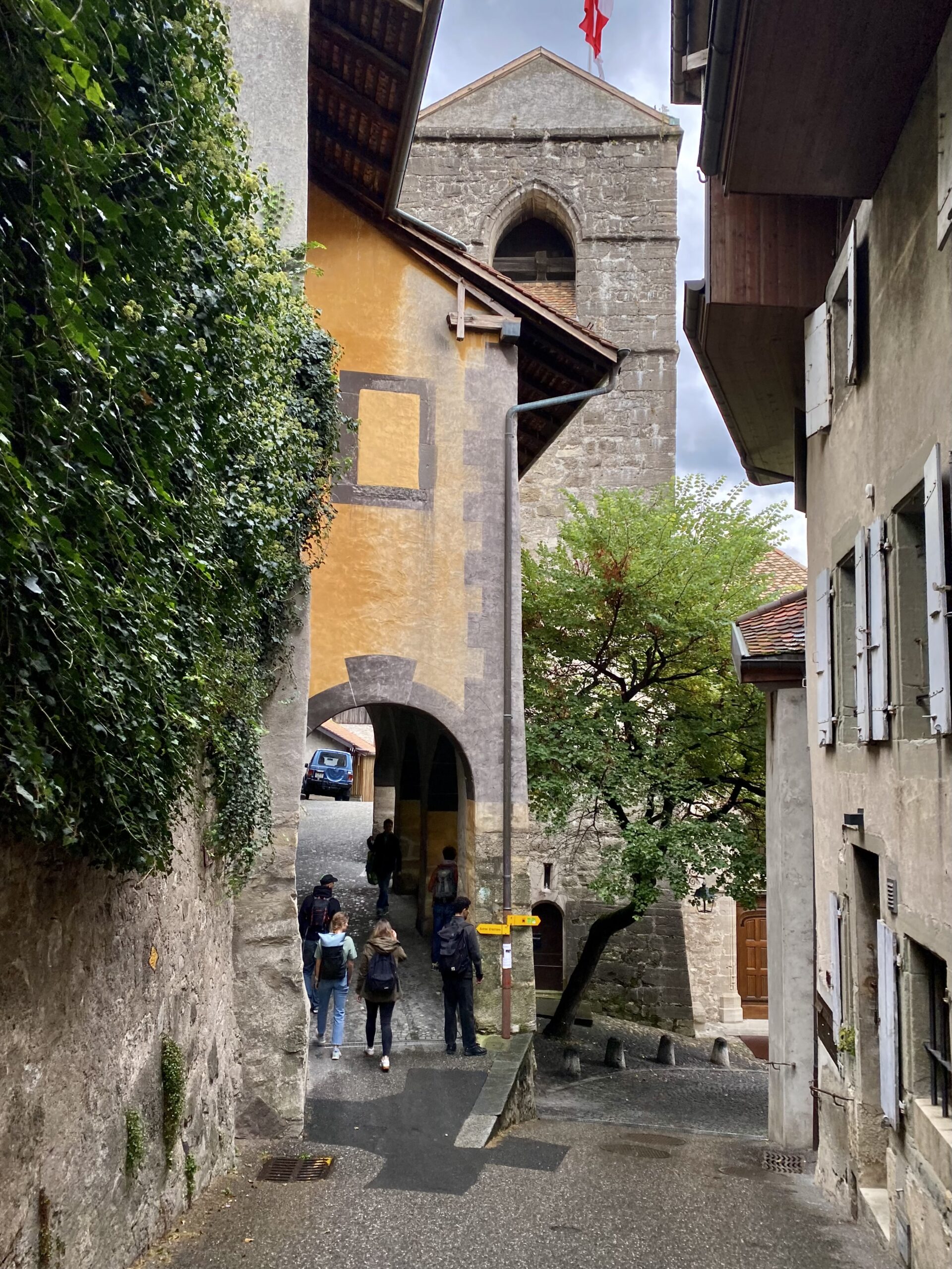 Vicolo lastricato di Saint-Saphorin con arco medievale e torre campanaria svizzera